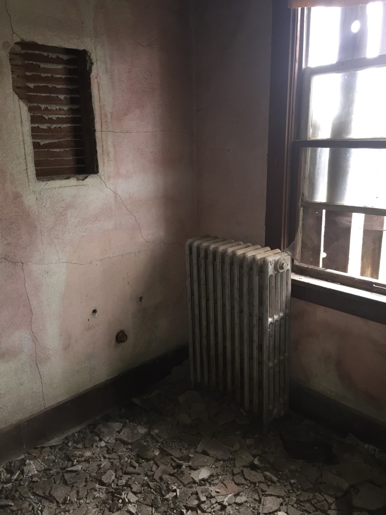 Corner with a radiator in once of the rooms of the ruins of the old hotel in Modena
